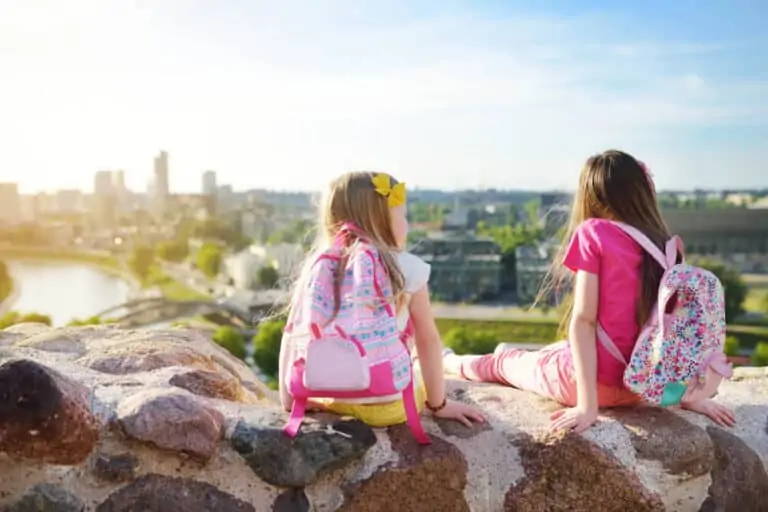 Cute little girls enjoying a view of Vilnius city from the Gediminas hill. Exploring tourist attractions with kids.