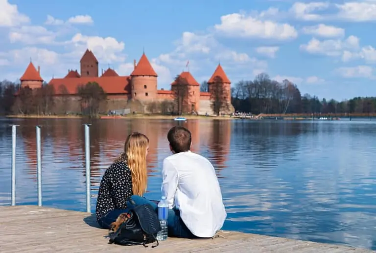Young couple looking at Trakai island castle at Galve lake, near Vilnius, Lithuania